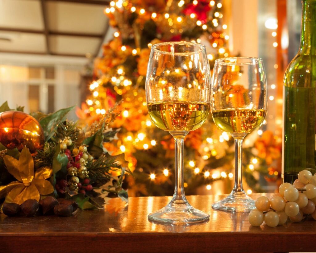 A beautiful shot of two glasses of alcohol on the counter with a christmas tree in the back