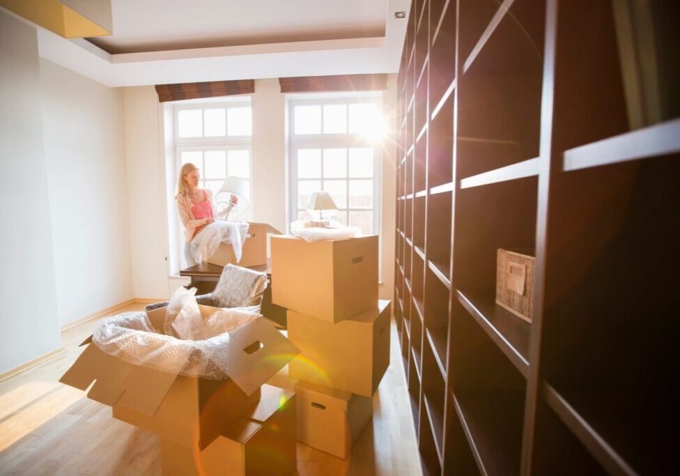 A woman standing in front of boxes on the floor.